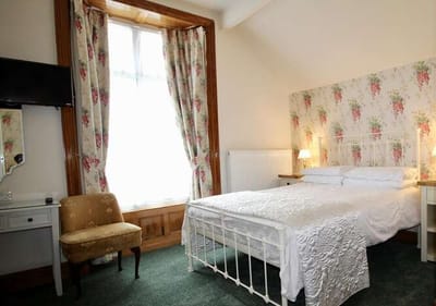 Brightly decorated private resident room with bed and chair