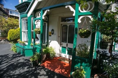Entrance of a charming assisted living facility with green accents