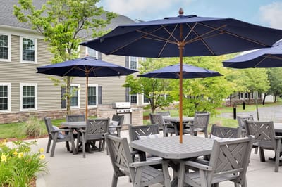 Outdoor seating area with umbrellas and grill