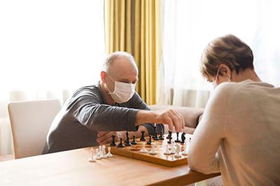 Two residents playing chess indoors.