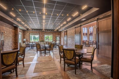 Bright and spacious common area with tables and chairs.