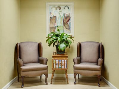 Cozy corner seating area with plants and artwork.