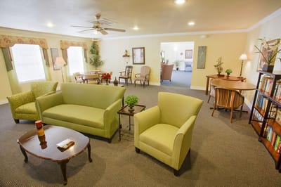 Cozy common area with green furniture and decor.
