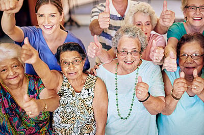 Group of smiling residents giving thumbs up