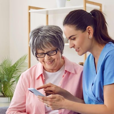 Staff assisting a resident with a smartphone