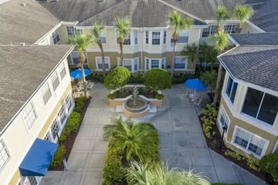 Aerial view of a courtyard featuring a fountain and palm trees
