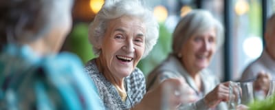 Smiling elderly residents enjoying a meal together