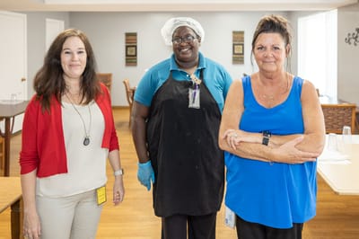 Three staff members posing in a common area