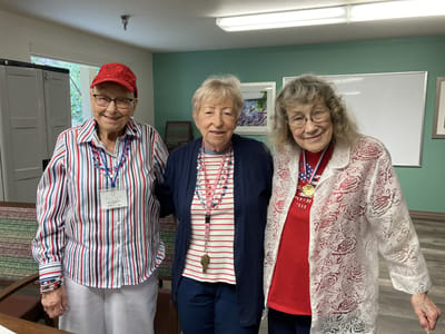 Three residents smiling in a community activity room