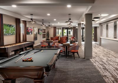 Bright activity room with a pool table and seating