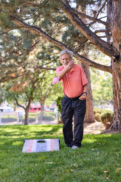 Resident playing cornhole in the garden