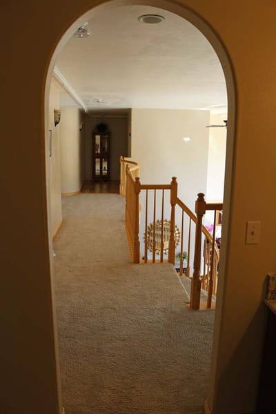 Interior view of a carpeted hallway with a stairway