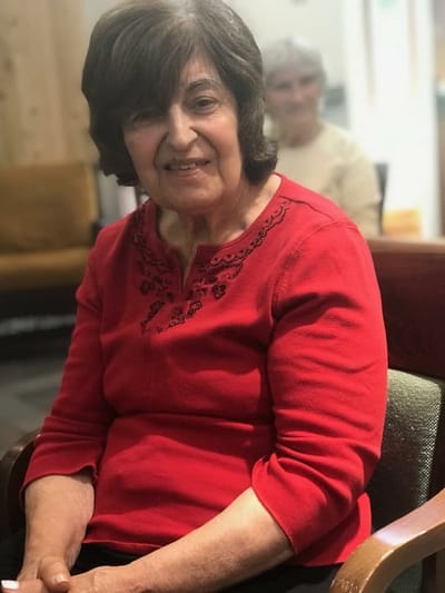 Resident sitting in a common area, smiling