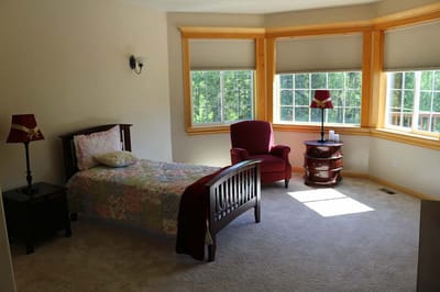 Cozy private resident room with a bed and chair