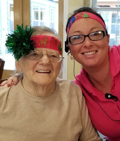 Resident and staff member sharing a joyful moment indoors