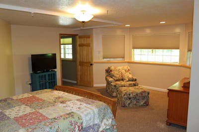 A cozy resident room with a bed and seating area