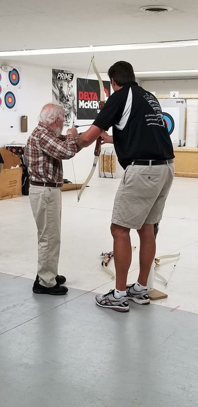Residents participating in an archery activity with assistance