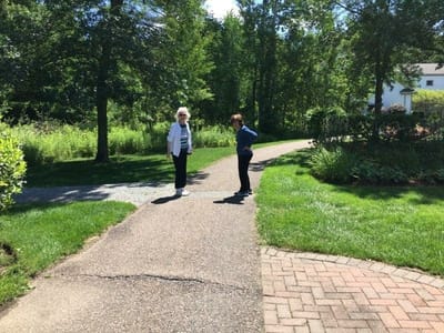 Residents walking on a path in a garden area