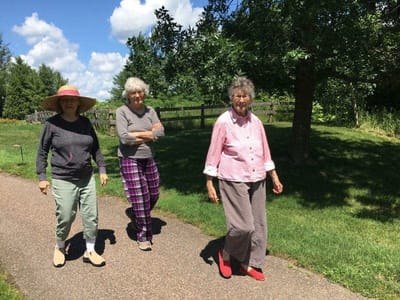 Three residents walking on a path in a garden