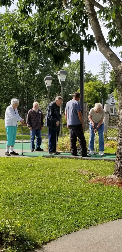 Residents enjoying mini-golf in a garden area