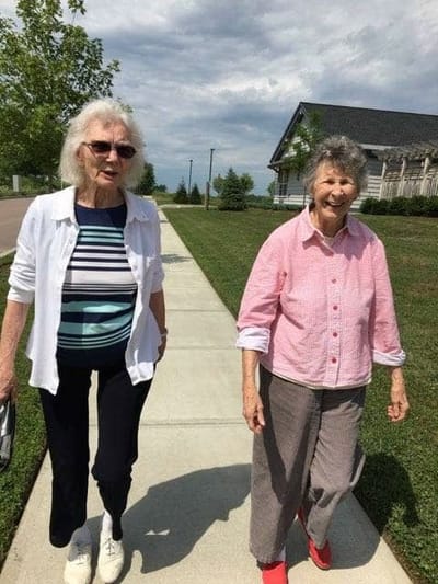 Two residents walking on a pathway beside the building