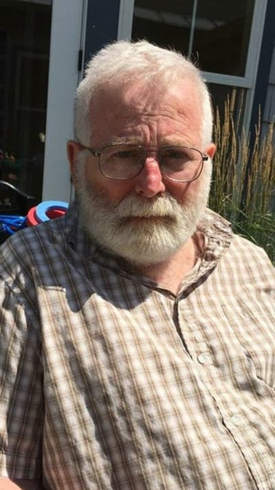 Senior man outside, sitting in a garden area