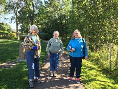 Three residents enjoying a walk in the garden