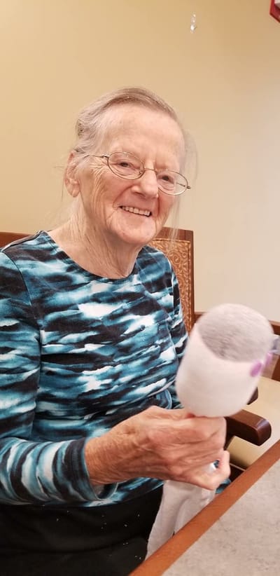 Resident smiling while holding a craft item