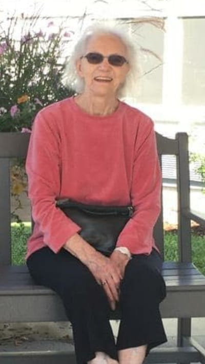 Senior resident enjoying time outside among flowers