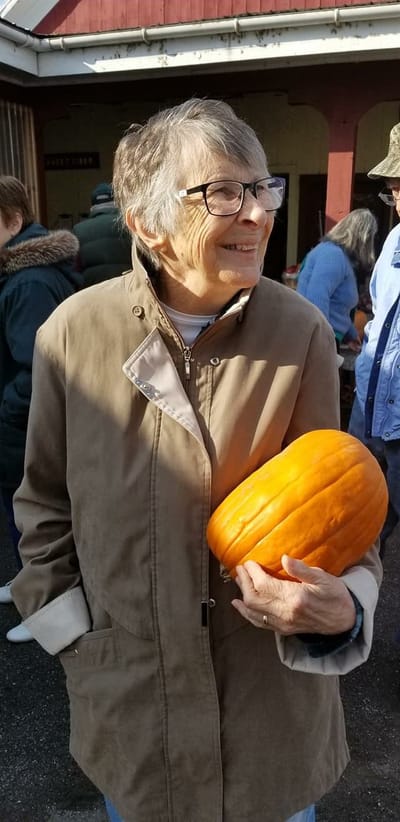Resident holding a pumpkin at a community event
