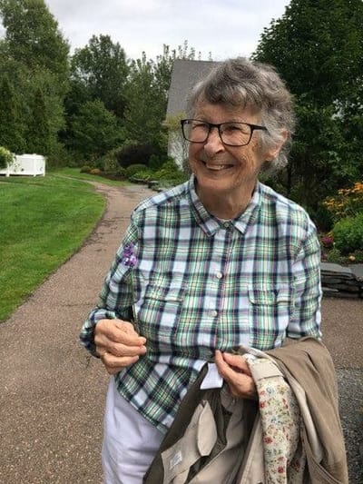 Senior woman smiling in a garden path