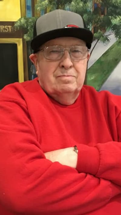 Senior resident posing with arms crossed in a common area