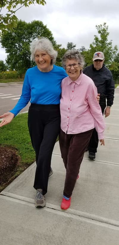 Two residents walking happily in a garden