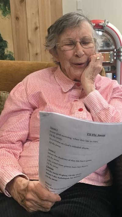 Resident enjoying a song with a sheet of music
