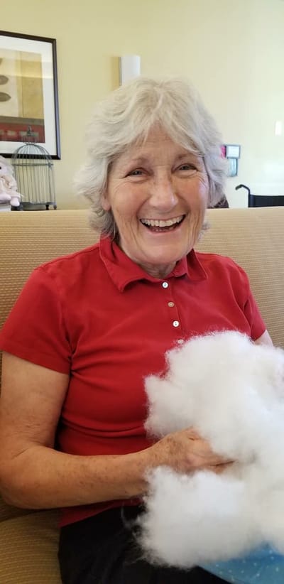 A resident smiling while holding cotton fluff