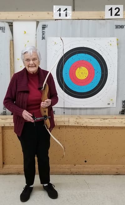 Senior woman holding a bow in an archery range