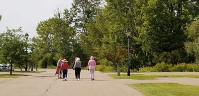 Residents walking together on a paved path in a park-like setting