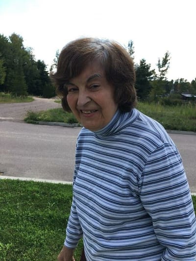 Senior woman smiling outdoors in a natural setting