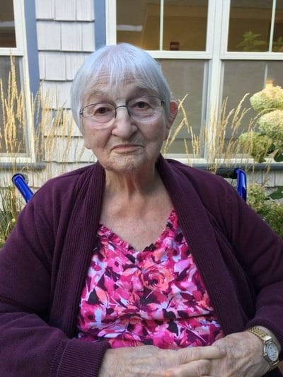 Senior resident sitting outdoors in a garden area