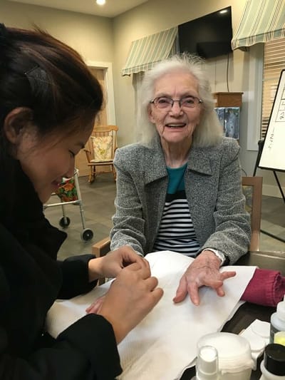 Resident enjoying a manicure session in a common area