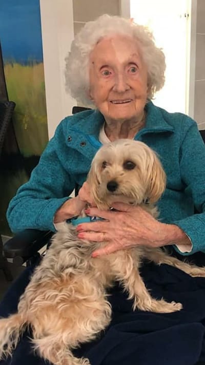 Resident smiling with a small dog