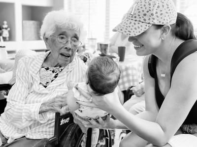 Residents interacting with a baby in a common area