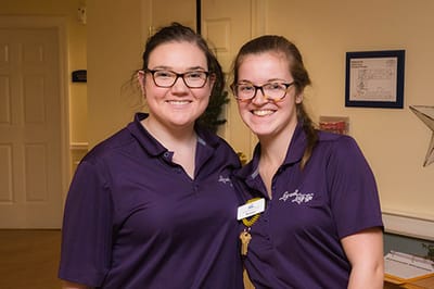 Two staff members smiling in a lobby area
