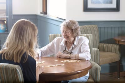 Resident enjoying a game with staff member indoors