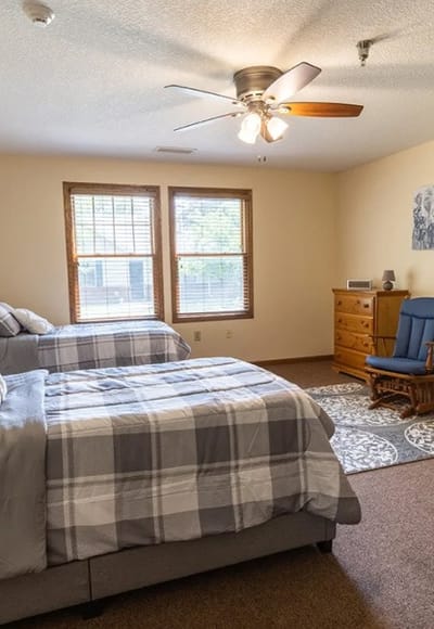 Bright and cozy bedroom with two beds and a rocking chair