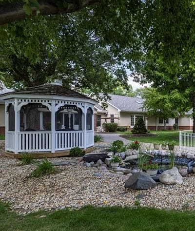 Garden gazebo surrounded by landscaping and a pond