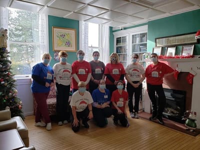 Staff posing together in a cozy common area during a celebration
