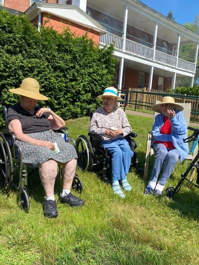 Three residents enjoying time outdoors in wheelchairs