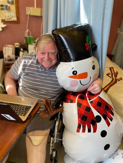 Resident smiling with an inflatable snowman