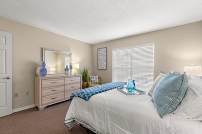 Brightly decorated resident room with a bed and dresser